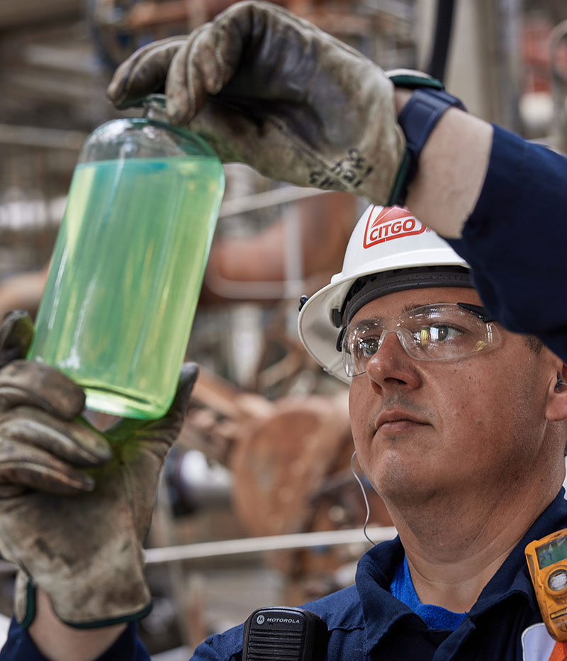 CITGO employee holding jar of solvents